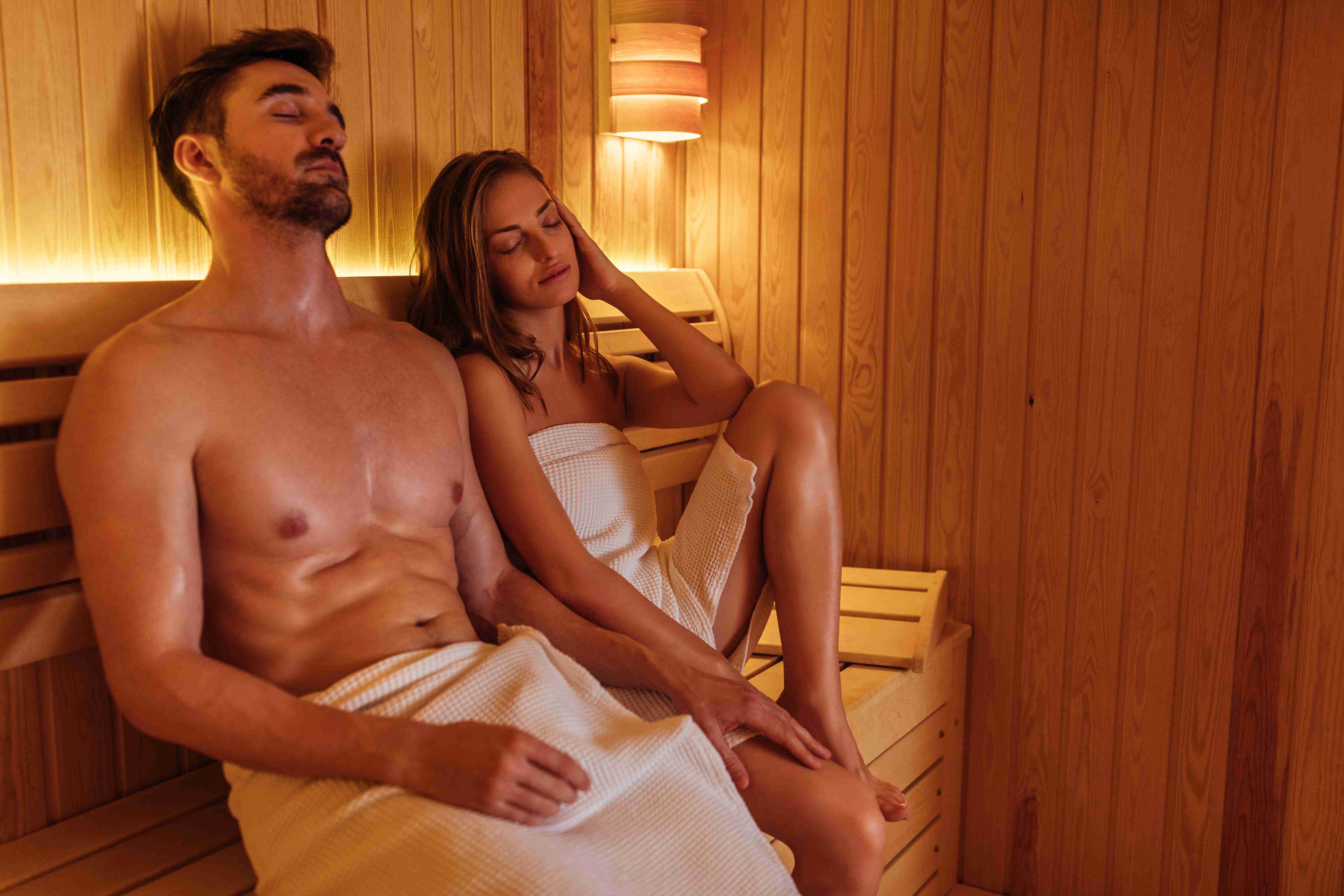 para owinięta ręcznikami w saunie