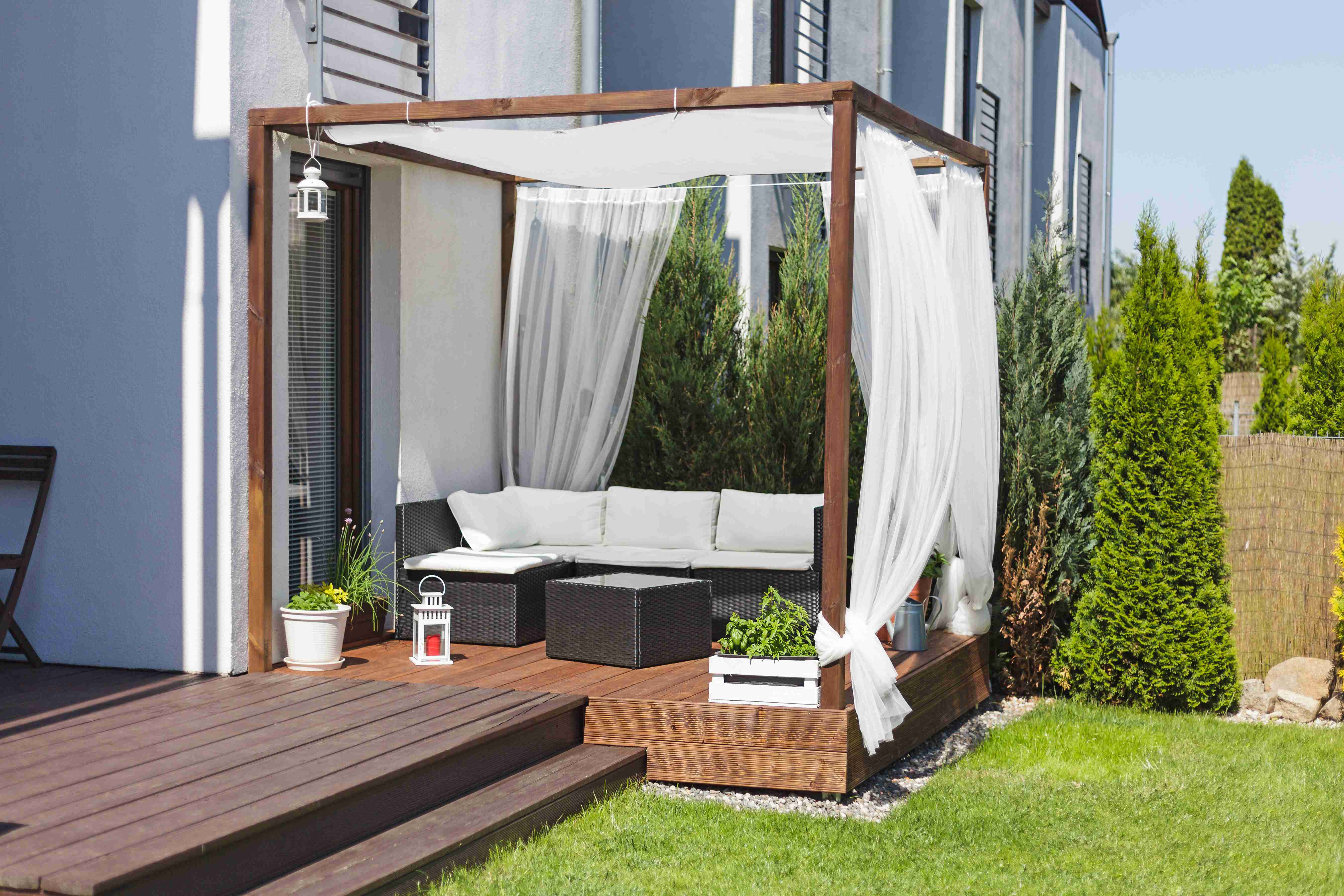 pergola z białymi zasłonami w ogrodzie